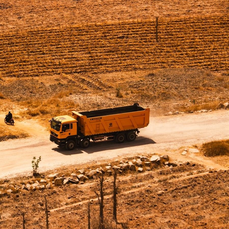 Camion-benne roulant sur une piste en terre, vu du ciel